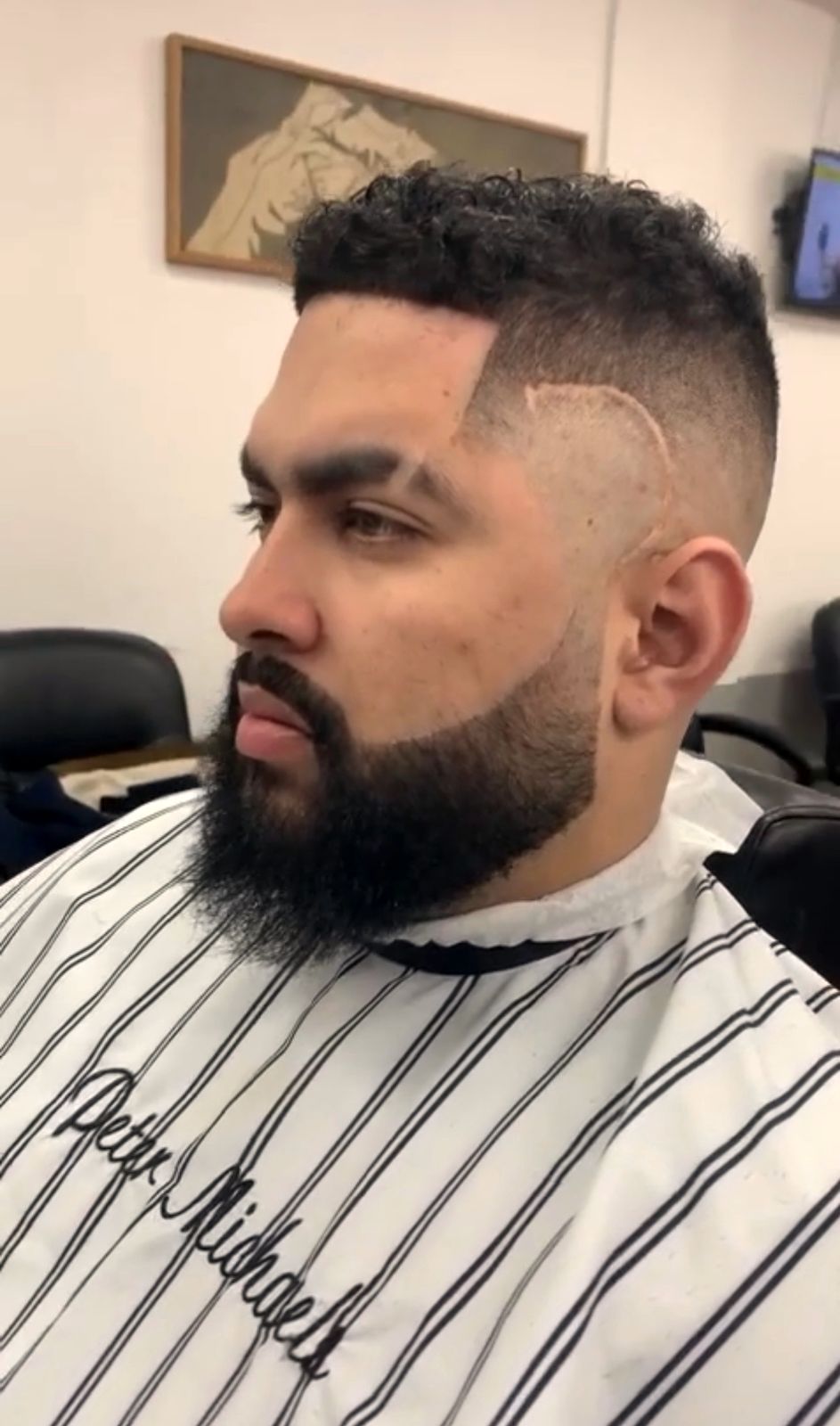 Full beard sculpted with a high fade